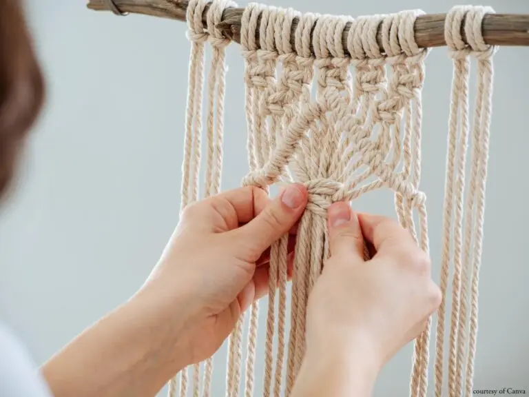 ropes hang from a piece of wood while hands tie knots to create a pattern