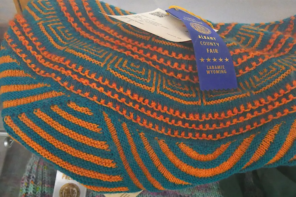 closeup details of a knit project with teal and orange thread