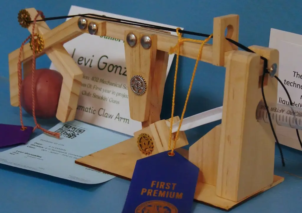 a functional model of a robotic arm powered by compressed air is displayed on a shelf