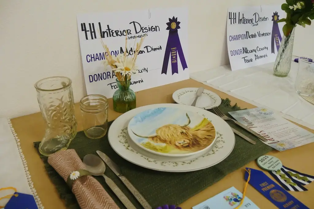 a winning place setting with a cow painted on a plate at the fair