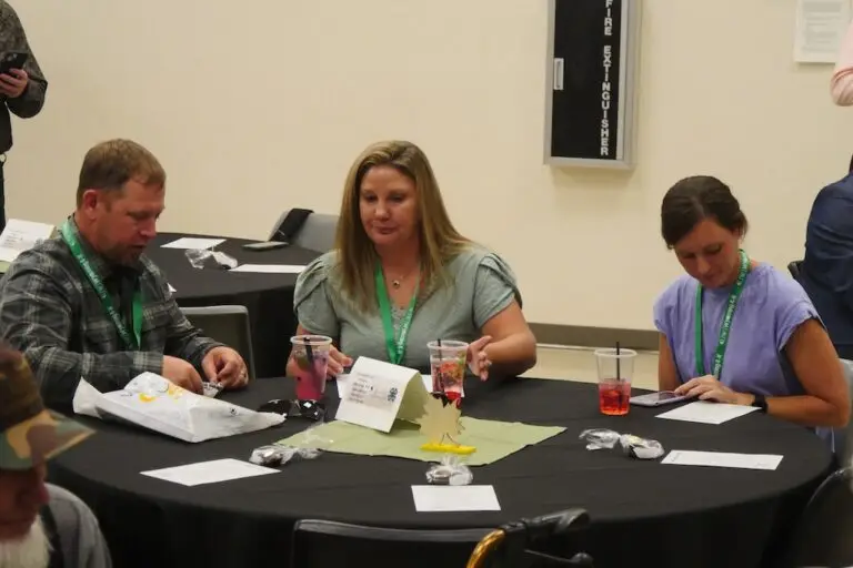 a group of people sit around a table at a meeting