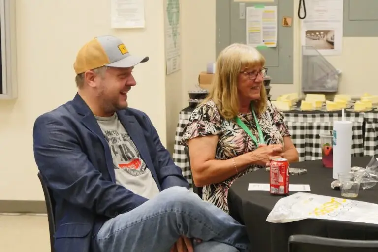 two people enjoy a laugh while sitting at a table together